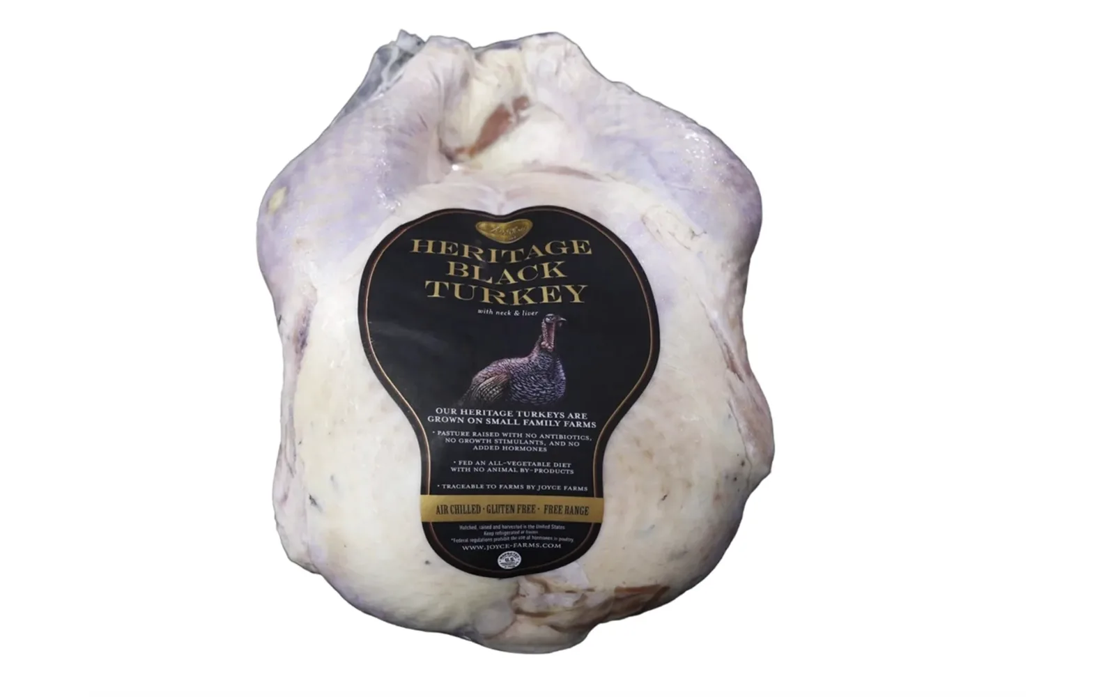 A whole raw Joyce Farms Heritage Black turkey, its black and gold label reading Heritage Black Turkey across the breast.