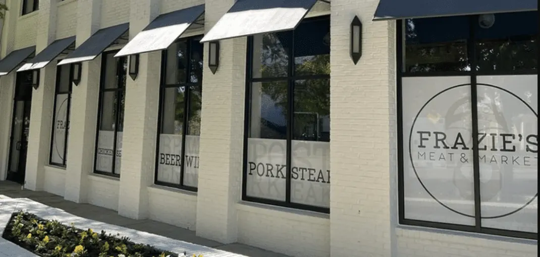 Frazie's Meat & Market storefront featuring large windows with signage for organic meats like "Pork Steak" and "Beer Wings," emphasizing high-quality, sustainably sourced products in Atlanta.