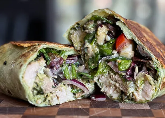 Hand-crafted gourmet wrap filled with grilled chicken, fresh greens, and vibrant vegetables, showcasing Frazie's Meat & Market's commitment to high-quality, locally sourced ingredients.