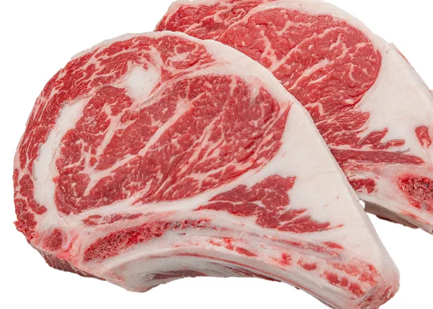 Two bone-in ribeye steaks showing heavy marbling.