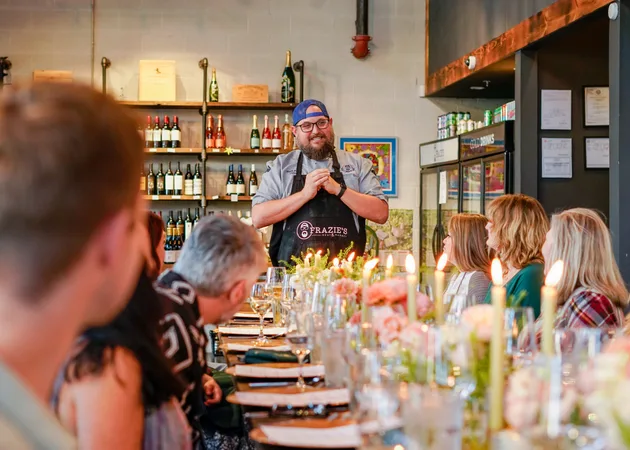 Mark Frazie talking to guests seated along a candlelit table at a Frazie's supper club.